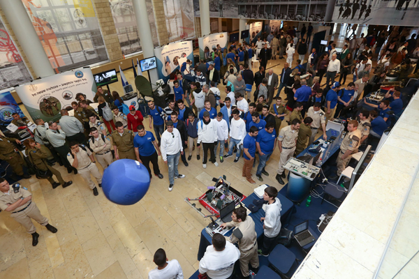 Crowds watched as this cadet innovation, a red robot, threw a large blue ball 2 meters in the air. It is more than fun – this has serious applications in the IDF.